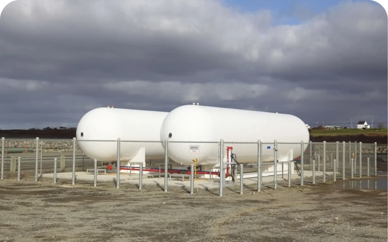 Industrial gas tanks under cloudy sky
